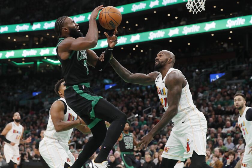 Boston Celtics' Jaylen Brown (7) shoots against Miami Heat's Dewayne Dedmon (21) during the first half of an NBA basketball game Friday, Dec. 2, 2022, in Boston. (AP Photo/Michael Dwyer)