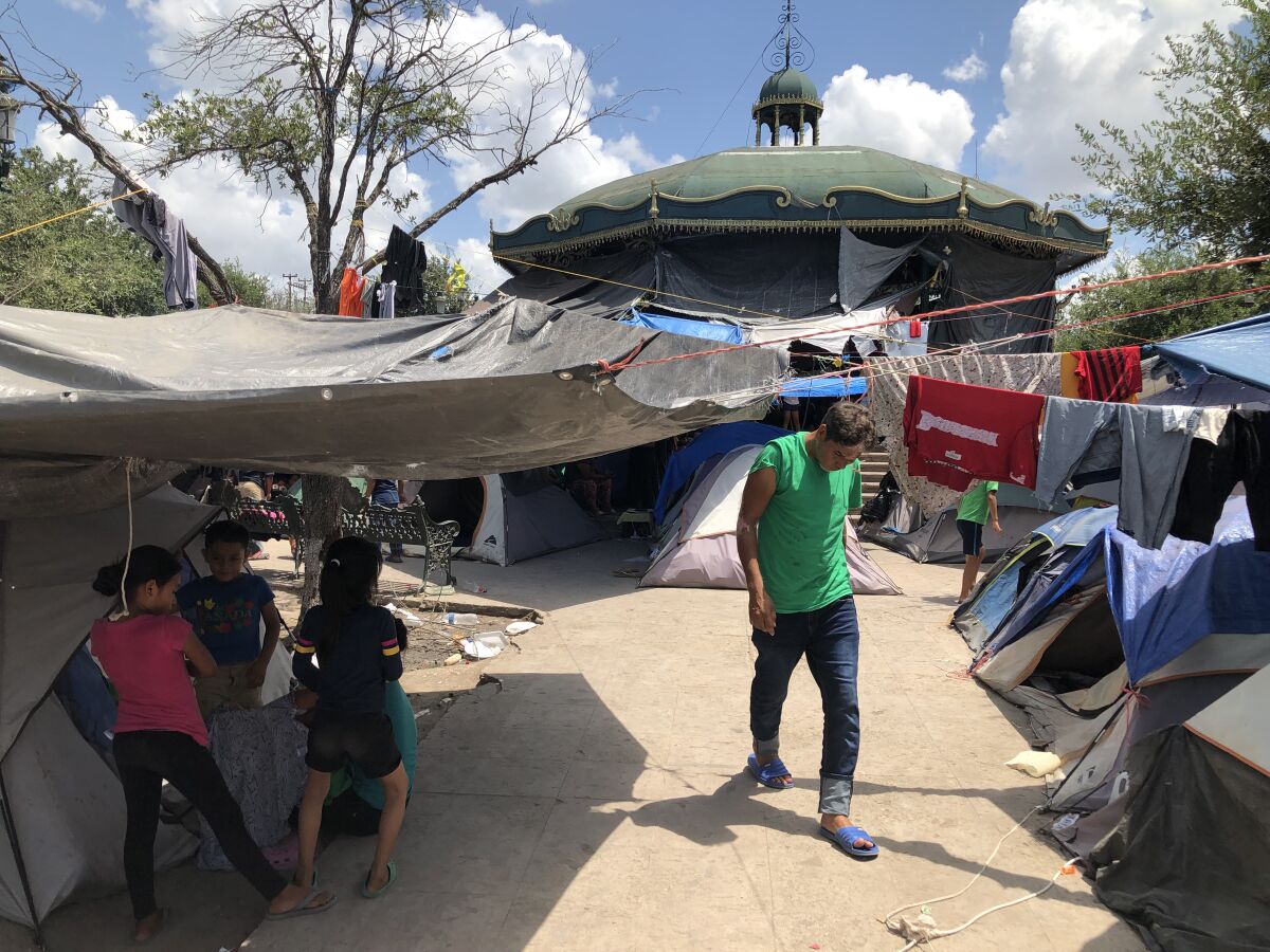 Children and an adult stand among tents and tarps