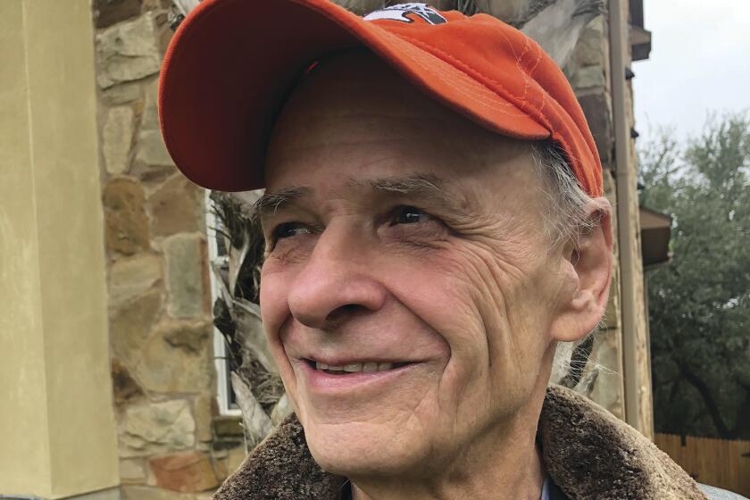 A man in an orange cap and a fur lined leather jacket.