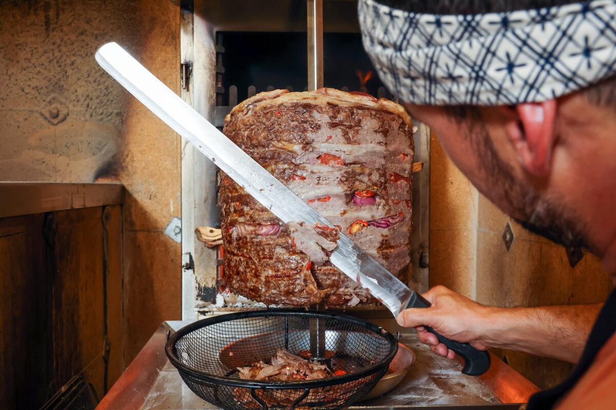 Restaurant chef-owner Ori Menashe carves shawarma off the turning spit at Saffy's.