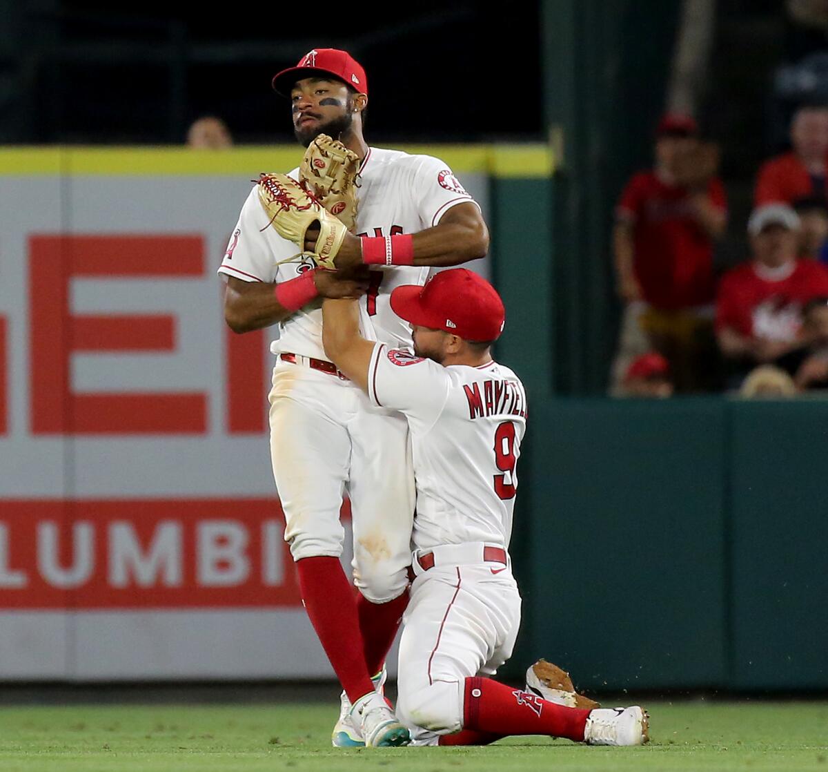 Angels second baseman Jack Mayfield gets tied up with teammate Jo Adell after catching a fly ball June 8, 2022.