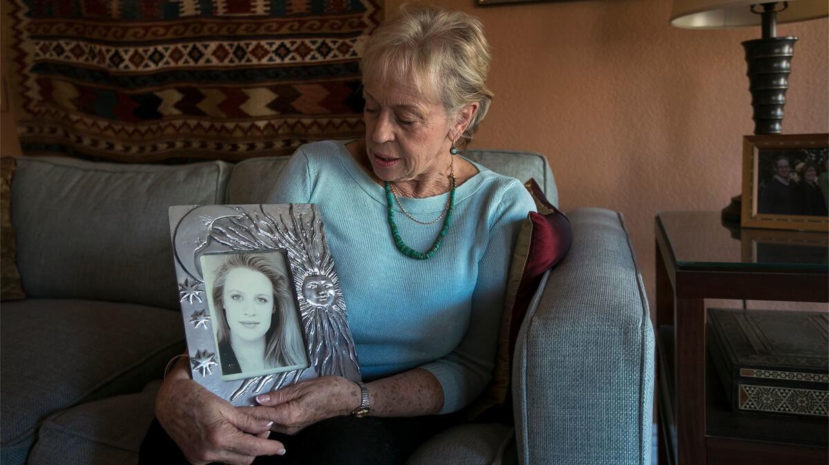 Sandy Sudweeks holds a framed photograph of her daughter, Adrienne “Sunny” Sudweeks, who was found raped and strangled to death in Adrienne’s Costa Mesa apartment in 1997.