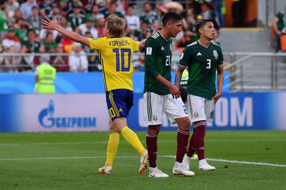 Sweden's Emil Forsberg celebrates after Mexico's Edson Alvarez, center, scored an own goal.