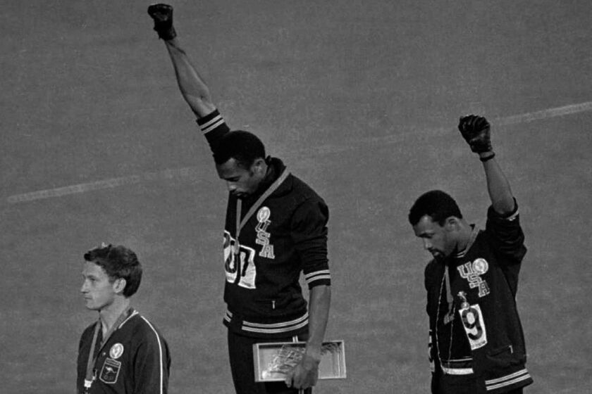 FILE - In this Oct. 16, 1968 file photo, United States athletes Tommie Smith, top center, and John Carlos, top right, extend their gloved fists skyward during the playing of the "Star-Spangled Banner" after Smith received the gold and Carlos the bronze for the 200-meter run at the Summer Olympic Games in Mexico City. Australia's silver medalist Peter Norman is at left. When Tommie Smith bowed his head and thrust a black-gloved fist toward the sky from the top of the Olympic podium 45 years ago, he was making a personal statement about human rights. With questions swirling over an anti-gay law in Russia, which will host the Winter Games in Sochi in February, today's athletes face a similar choice, Smith told The Associated Press Sunday, Sept. 8, 2013, at a track and field meet in Rieti, Italy. (AP Photo/File)