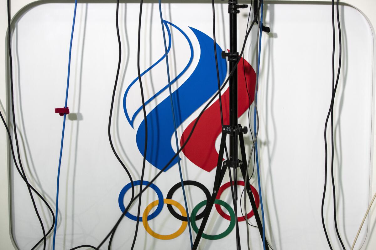 Wires go to microphones above a logo of the Russian Olympic Committee during President of the Russian Olympic Committee Stanislav Pozdnyakov's news conference in Moscow, Russia, Monday, Dec. 9, 2019. The World Anti-Doping Agency has banned Russia from the Olympics and other major sporting events for four years, though many athletes will likely be allowed to compete as neutral athletes. (AP Photo/Pavel Golovkin)