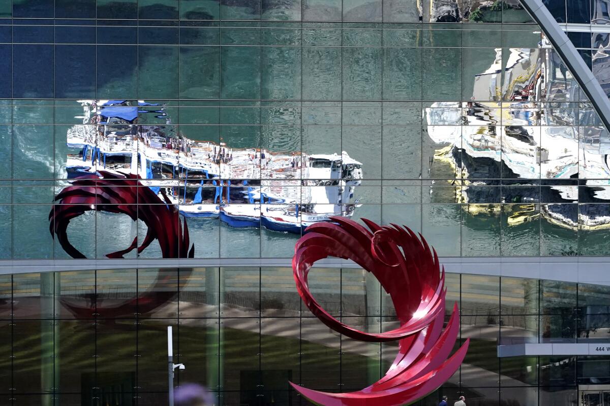 Chicago River tour boats are reflected by a building window in Chicago, Wednesday, Sept. 1, 2021. Chicago nonprofit Current in 2019 installed three sensors in the river's three main branches to continuously estimate the amount of bacteria from human and other warm-blooded animals' waste.(AP Photo/Nam Y. Huh)