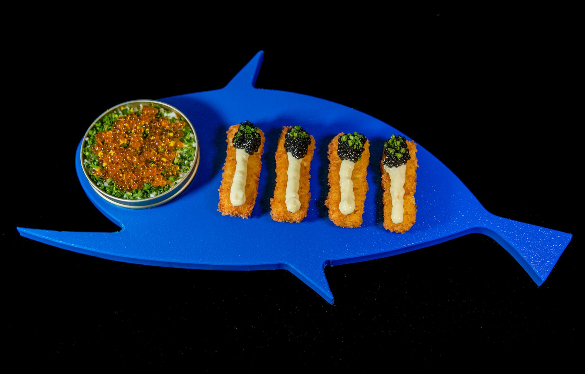 A fish-shaped blue tray holds fish sticks