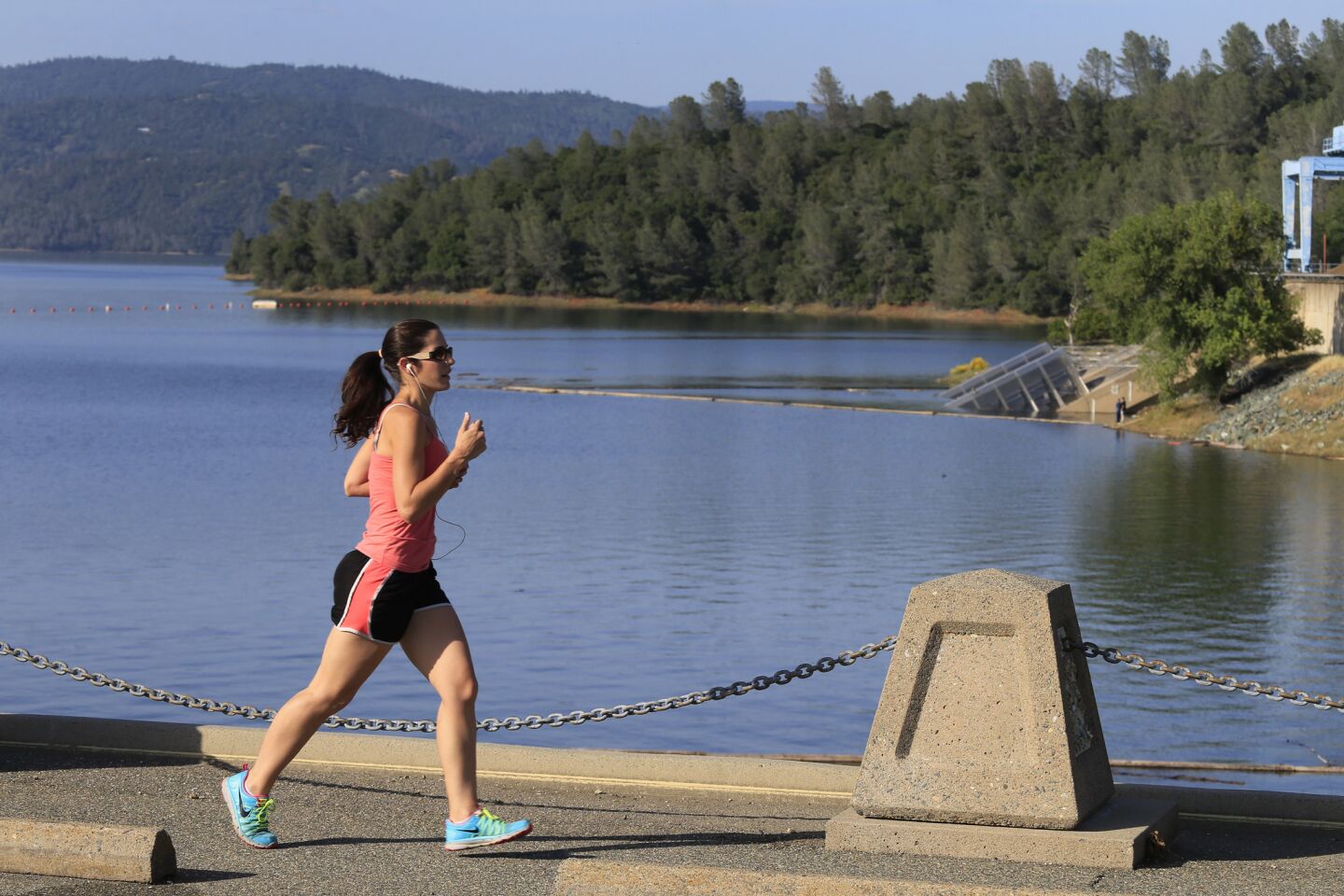 A runner crosses Lake Oroville Dam.
