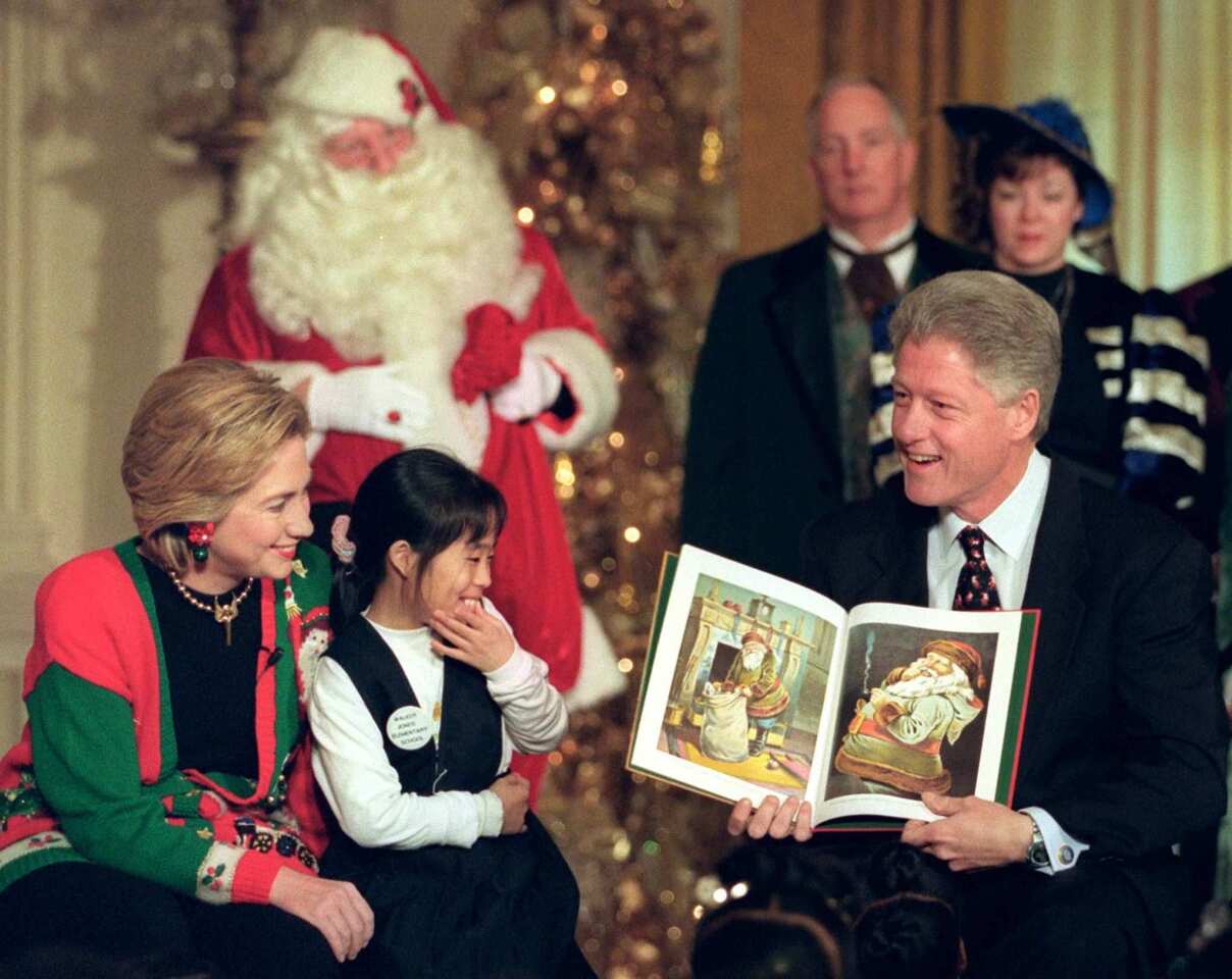 US President Bill Clinton (R) reads Clement Clark's poem.