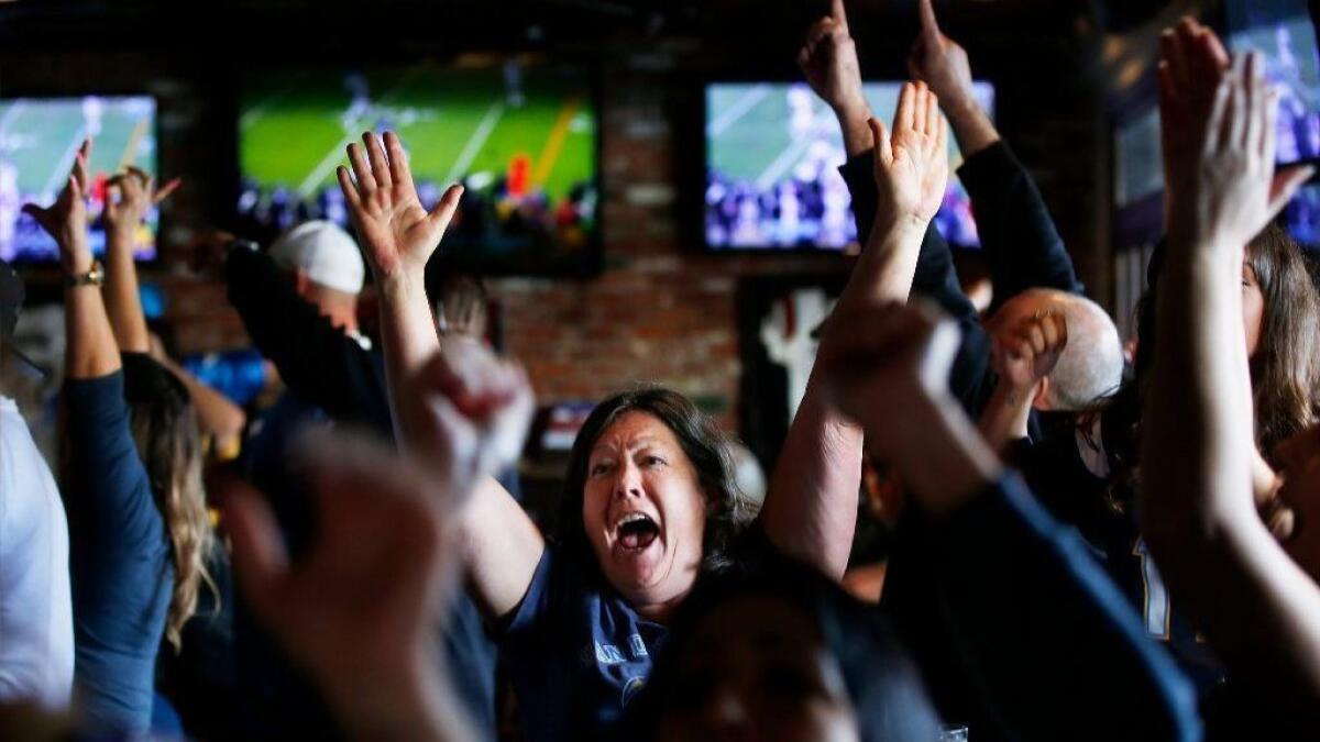 Chargers fans, including Teri Brown, center, celebrate at McGregor's Ale House in Mission Valley as the team beat the Ravens in a wildcard playoff game on Jan. 6, 2019.