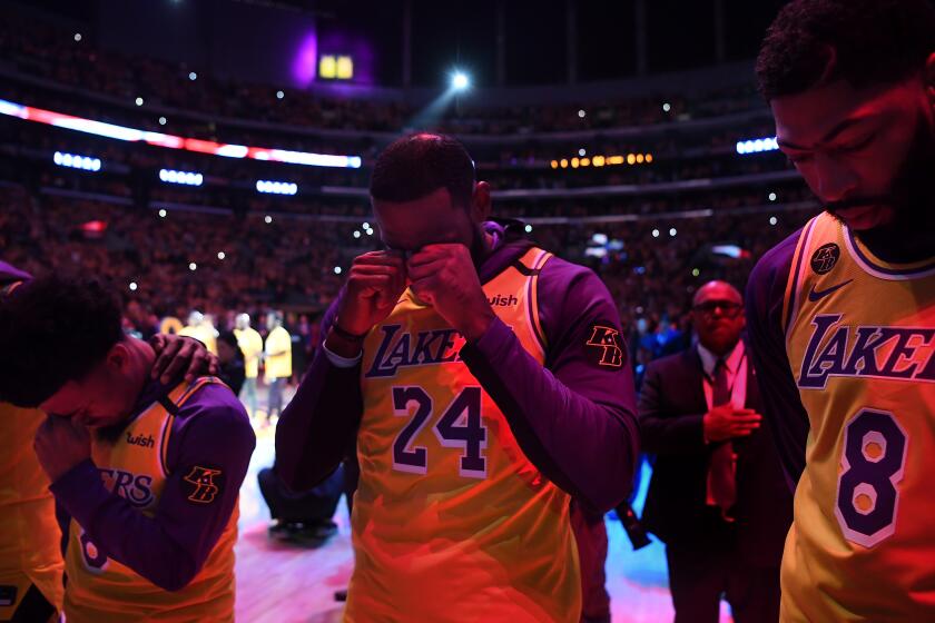 LOS ANGELES, CALIFORNIA JANUARY 31, 2020-From left, Quin Cook, LeBron James and Anthony Davis try to hold back emotions as they honor Kobe Bryant at the Staples Center Thursday. (Wally Skalij/Los Angeles Times)