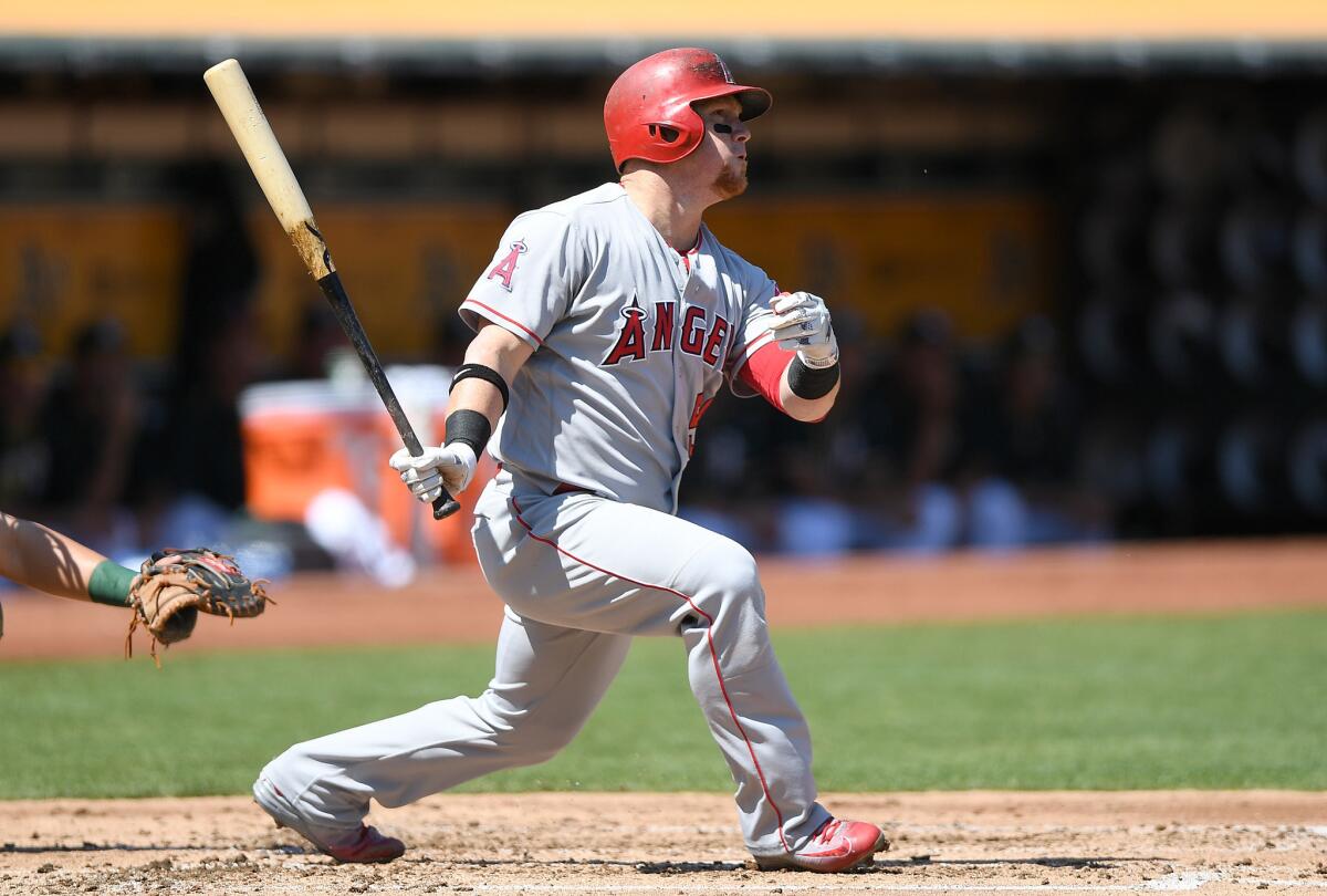 Angels outfielder Kole Calhoun (56) swings and watches the flight of his ball as he hits a solo home run against the Oakland Athletics in the top of the second inning.