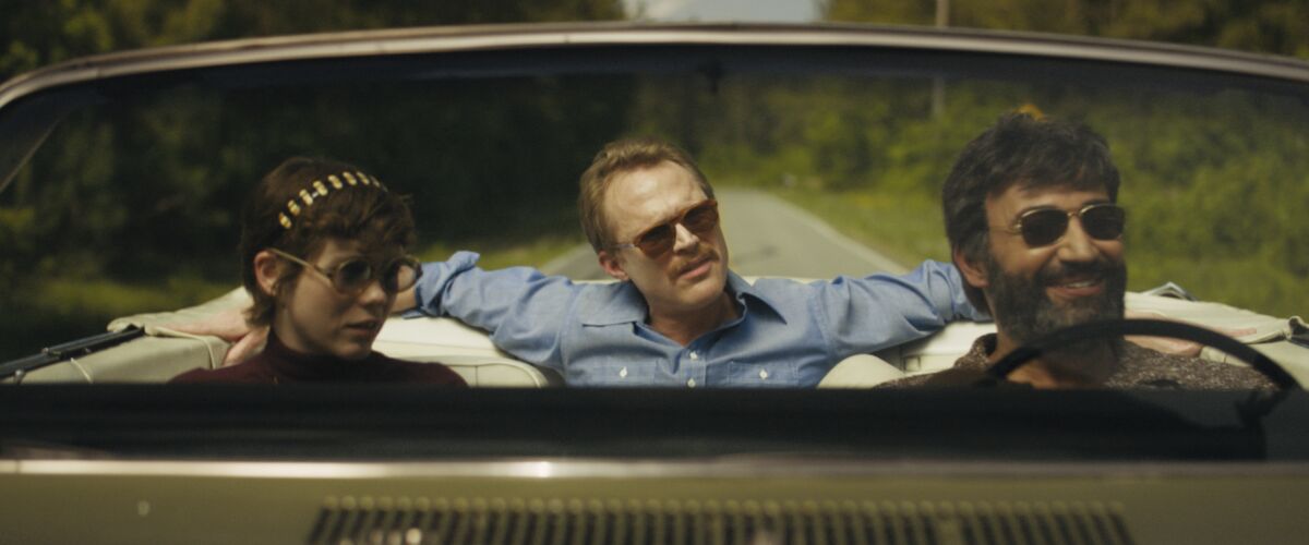 Sophia Lillis, left, Paul Bettany and Peter Macdissi ride in a convertible in the movie "Uncle Frank."