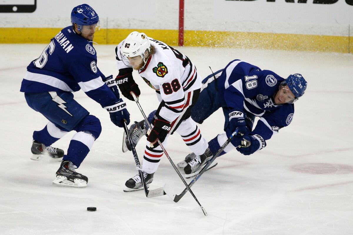 Blackhawks right wing Patrick Kane battles Lightning defenseman Anton Stralman (6) and left wing Ondre Palat (18) for the puck during the first period of Game 1.