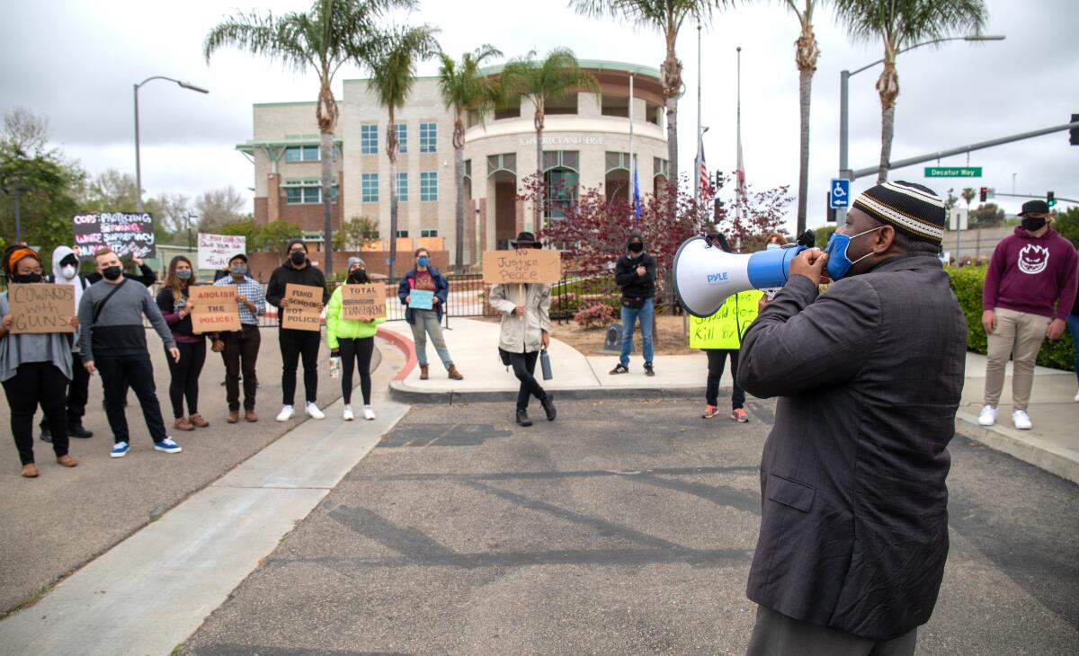 Yusef Miller, with the North County Equity and Justice Coalition, rallies outside the Escondido Police Station.