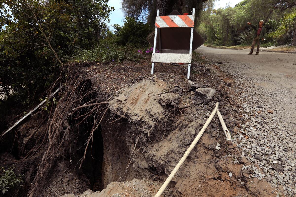 A man standing near a growing fissure in the Abalone Cove neighborhood of Rancho Palos Verdes.