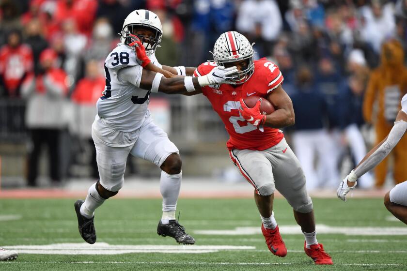 COLUMBUS, OH - NOVEMBER 23: J.K. Dobbins #2 of the Ohio State Buckeyes fends off Lamont Wade #38 of the Penn State Nittany Lions while picking up first down yardage in the second quarter at Ohio Stadium on November 23, 2019 in Columbus, Ohio. (Photo by Jamie Sabau/Getty Images)