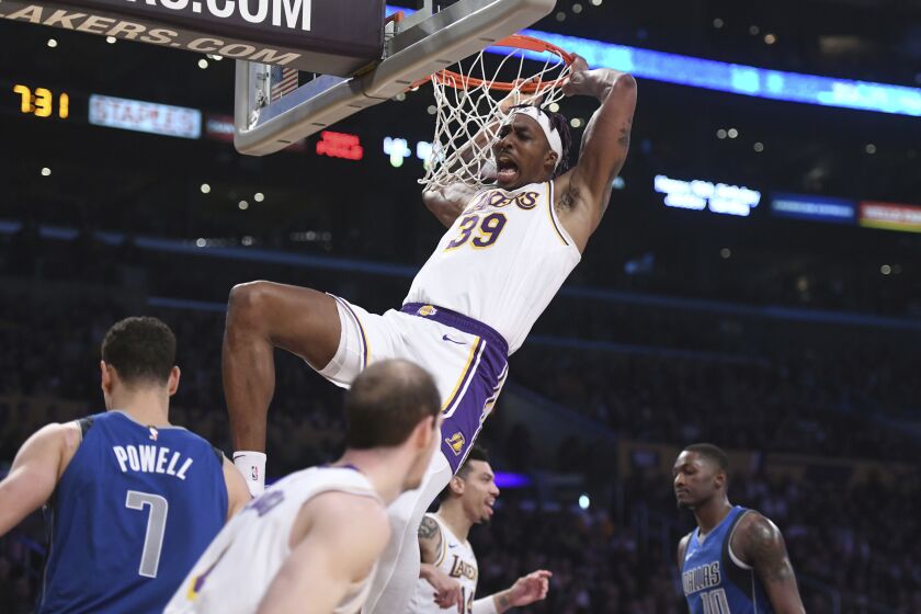 Los Angeles Lakers center Dwight Howard reacts after dunking against the Dallas Mavericks during the first half of an NBA basketball game Sunday, Dec. 29, 2019, in Los Angeles. (AP Photo/Michael Owen Baker)