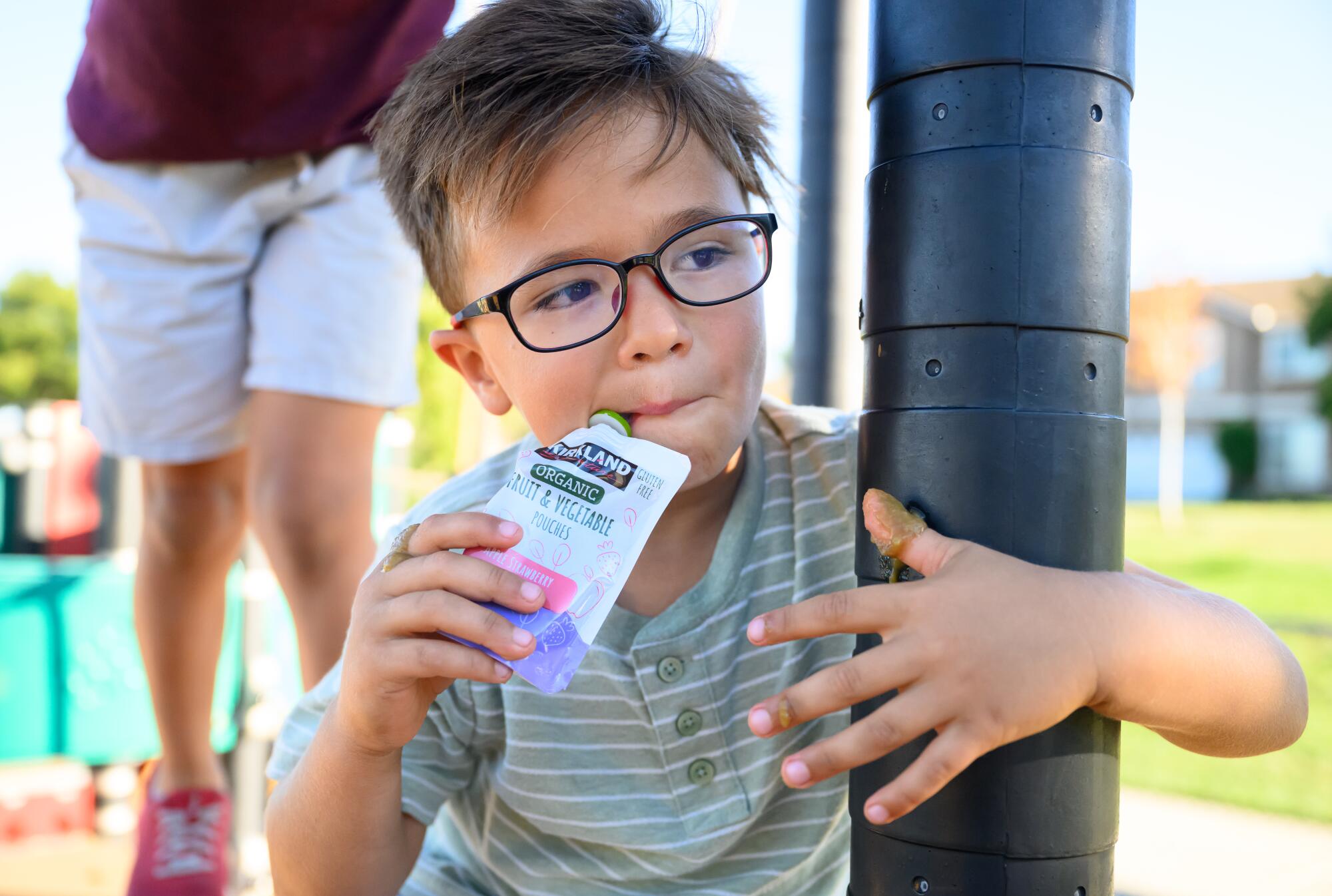 A five-year-old boy with a food pouch.  