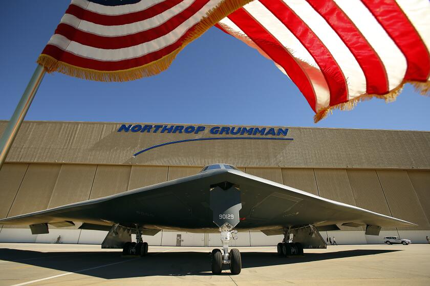 PALMDALE, CA JULY 17, 2014 -- The US flag flies near the U.S. Air Force's B-2 Spirit Stealth bomber "Spirit of Georgia" at the Northrop Grumman Corp. facility at U.S. Air Force Plant 42 in Palmdale on July 17, 2014 as Northrop Grumman hosts the 25th anniversary celebration of the first flight in the same location at the Palmdale Aircraft Integration Center of Excellence at U.S. Air Force Plant 42. Just as they had on that historic day 25 years ago, several hundred Northrop Grumman employees, civic leaders and Air Force personnel stood along the fence line in Palmdale to watch a B-2 stealth bomber taxi onto the runway for flight following the ceremony. (Al Seib / Los Angeles Times)