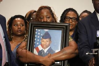 CORRECTS NAME Chantemekki Fortson, mother of Roger Fortson, a U.S. Navy airman, holds a photo of her son during a news conference with Attorney Ben Crump, Thursday, May 9, 2024, in Ft. Walton Beach, Fla. Fortson was shot and killed by police in his apartment on May 3, 2024. (AP Photo/Gerald Herbert)