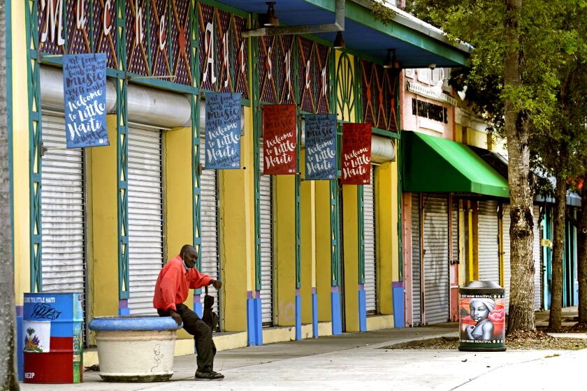 A man sits outside of the Little Haiti Cultural Center in the Little Haiti neighborhood of Miami, Wednesday, July 7, 2021.