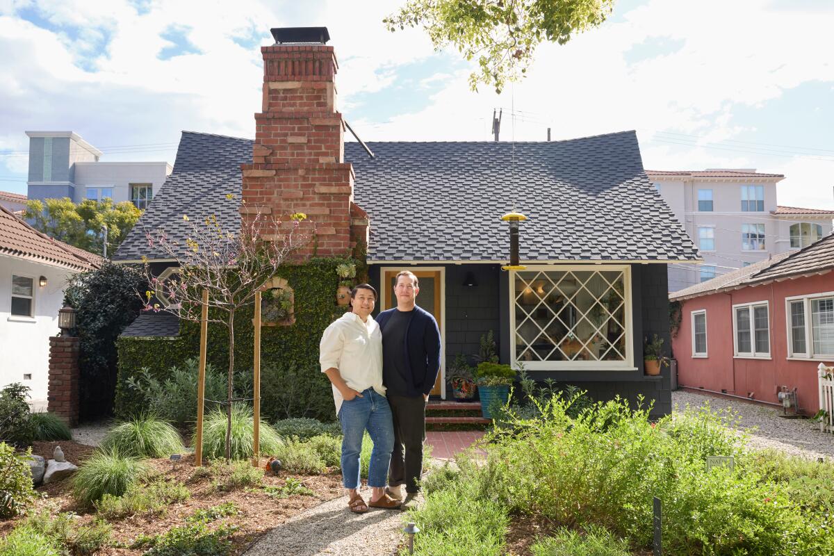 Michael Solberg & Khoi Pham in the front yard of their storybook cottage