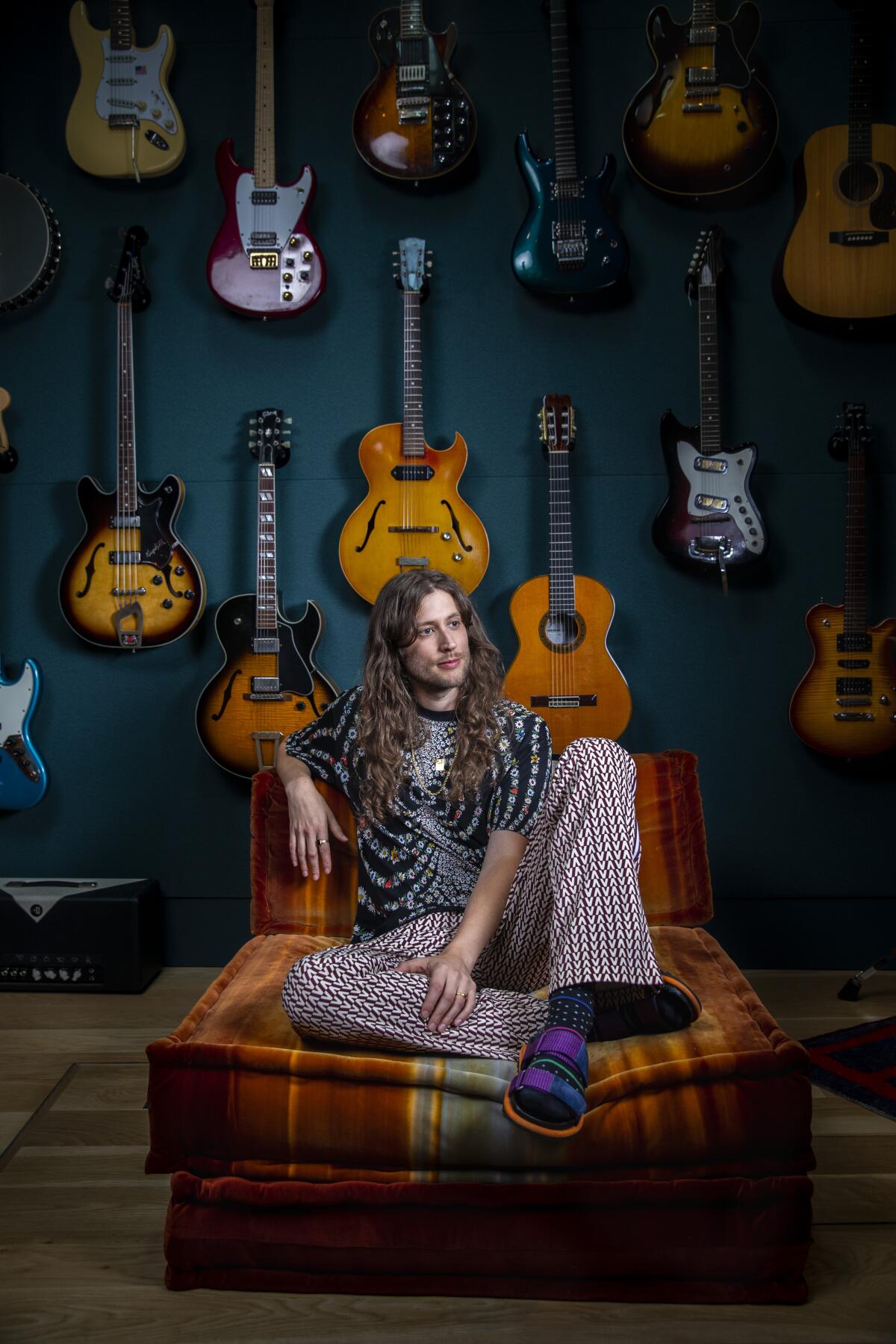 Ludwig Göransson in his Glendale recording studio, sitting in front of a wall of guitars.
