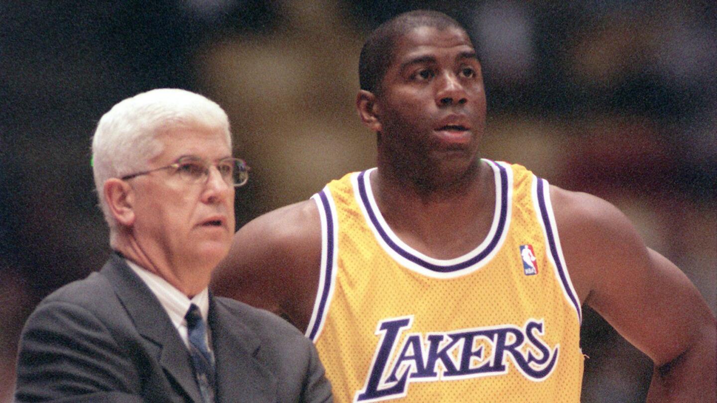 Lakers star Magic Johnson speaks with Coach Del Harris during a game at the Forum in February 1996.