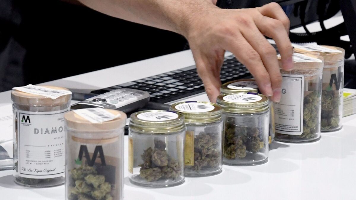 An employee lines up cannabis products at Essence Vegas Cannabis Dispensary after recreational marijuana sales began.