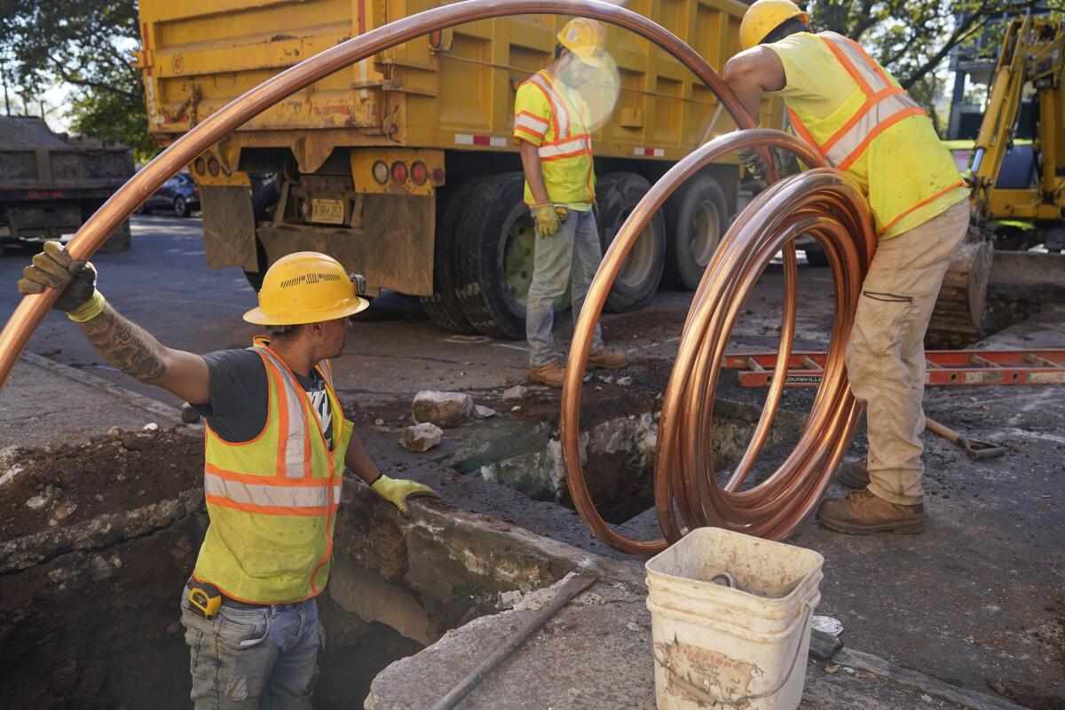 Workmen prepare to replace older water pipes with a new copper one in Newark, N.J., Thursday, Oct. 21, 2021. An ambitious program to replace thousands of residential lead water lines in New Jersey's largest city is about to be completed years ahead of schedule. (AP Photo/Seth Wenig)