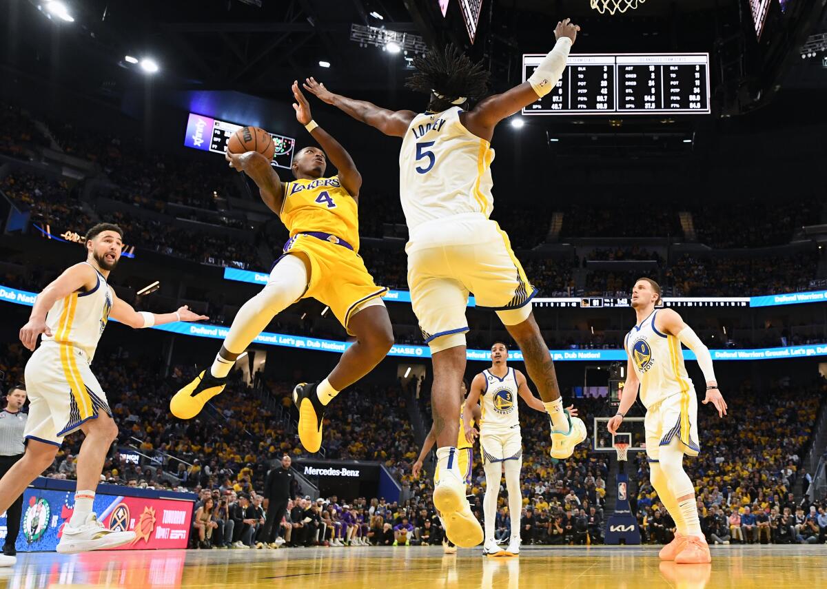 Lakers guard Lonnie Walker scores a basket against Warriors forward Kevon Looney during the second half of Game 5.