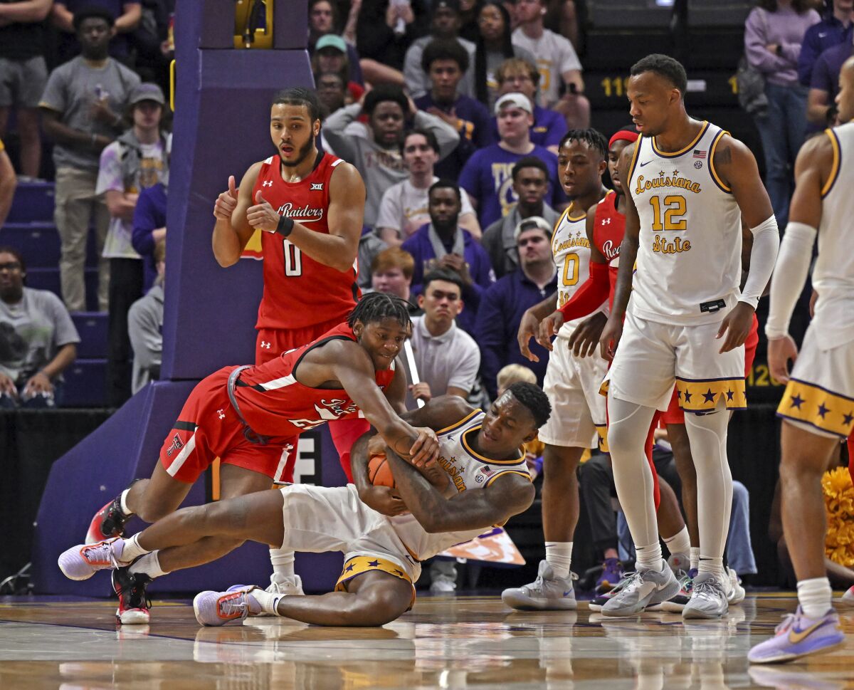 LSU center Kendal Coleman (4) pulls Texas Tech guard Elijah Fisher (22) down to the court as the pair vie for the jump ball during an NCAA college basketball game on Saturday, Jan. 28, 2023, in Baton Rouge, La. (Hilary Scheinuk/The Advocate via AP)