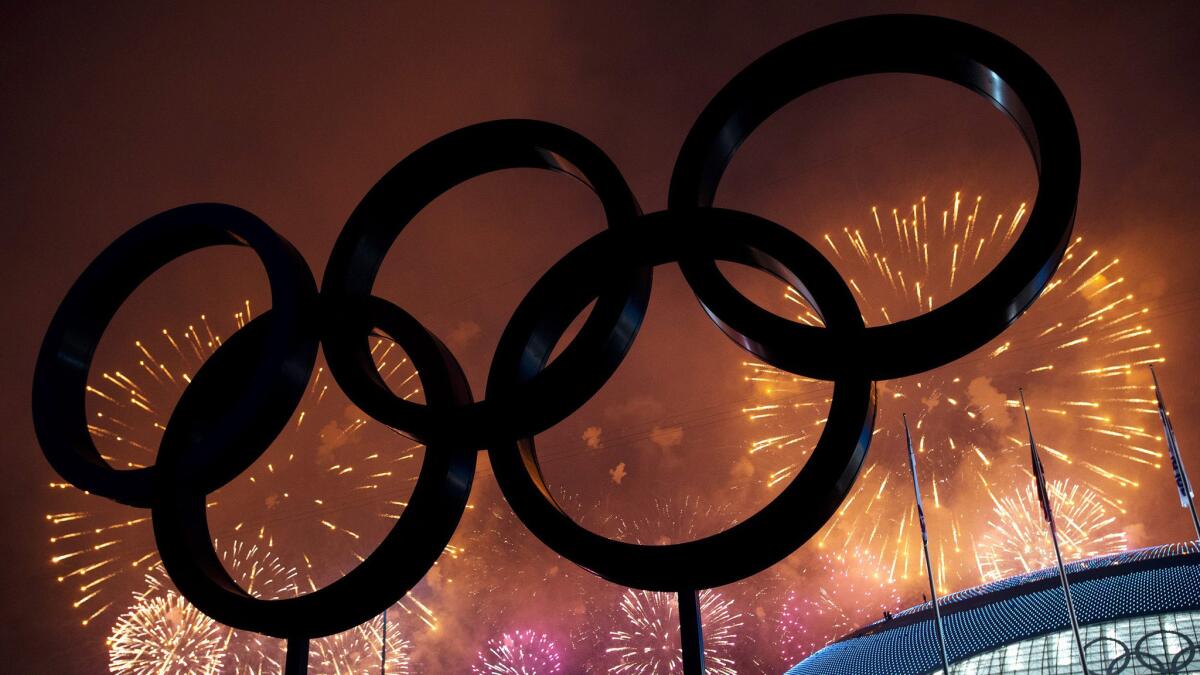 The Olympic rings are silhouetted as fireworks light up the night sky during the closing ceremonies of the 2014 Sochi Olympic Games.