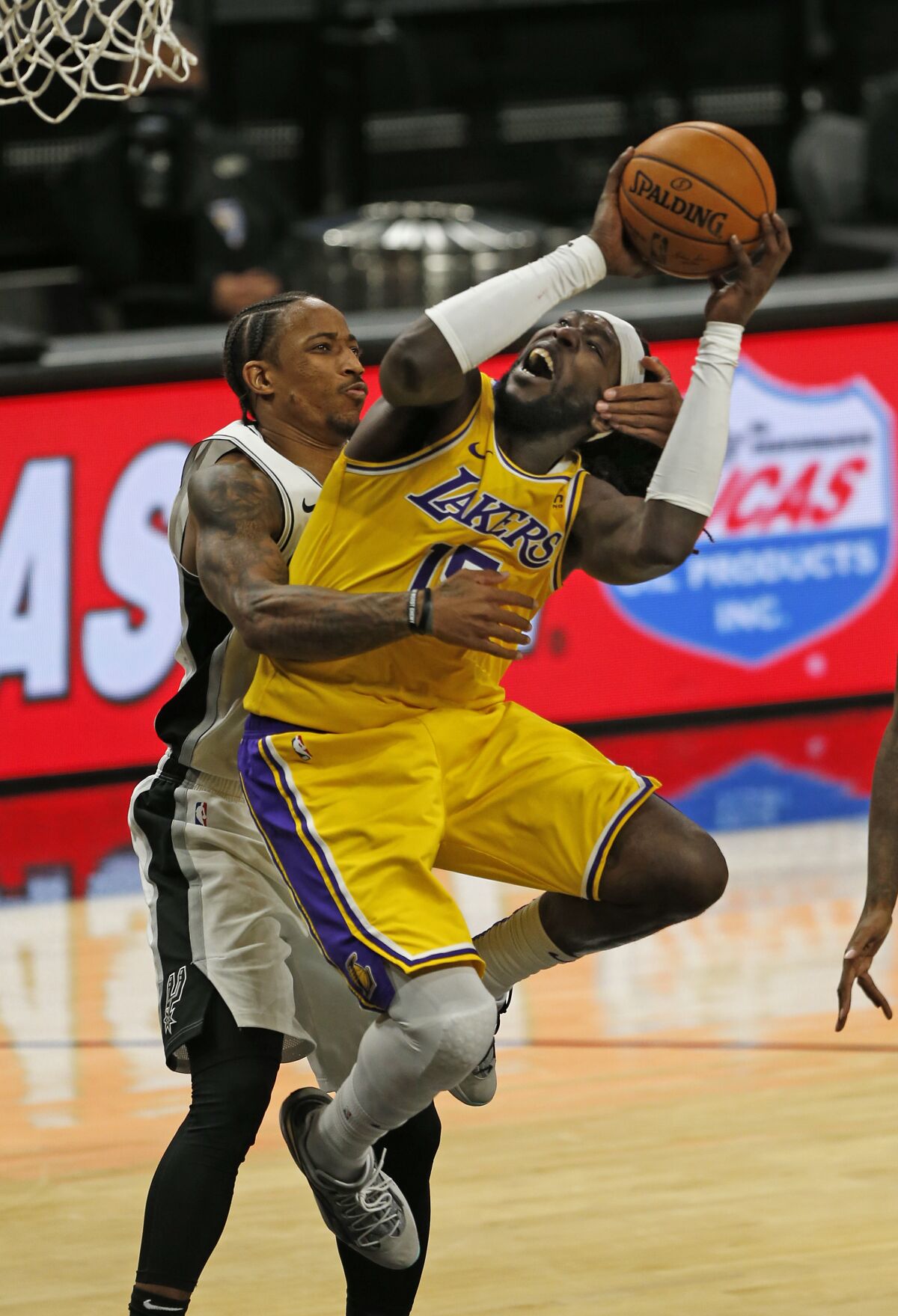 Lakers center Montrezl Harrell is fouled by Spurs guard DeMar DeRozan during their game Dec. 30, 2020, in San Antonio.