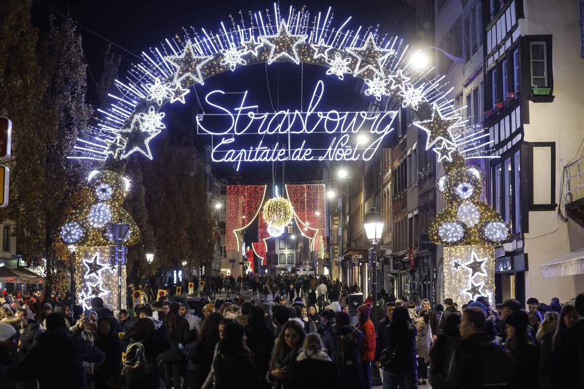 Personas pasean en el mercado navideño de Estrasburgo, uno de los más antiguos y grandes en Europa.