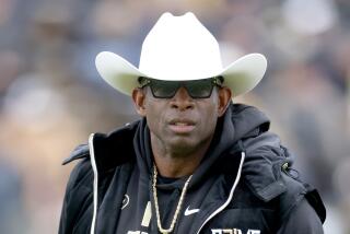 Colorado coach Deion Sanders watches as his team warms before playing their spring game