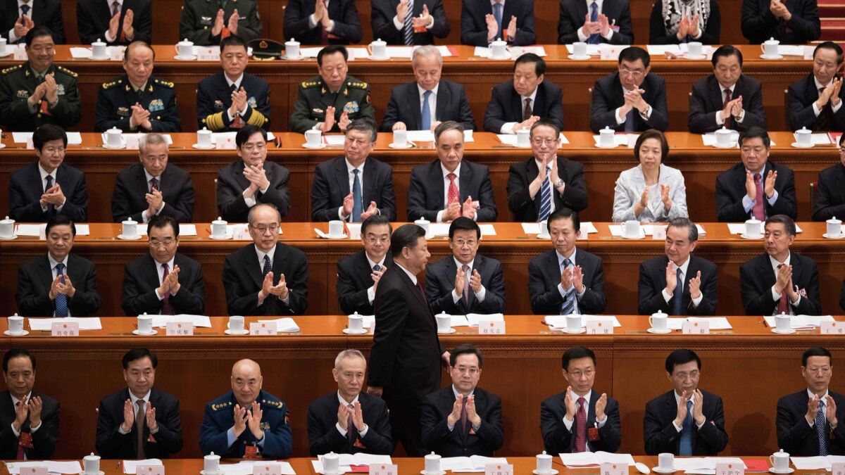 Delegates applaud as China's President Xi Jinping walks past after he delivered a speech during the closing session of the National People's Congress on Tuesday.