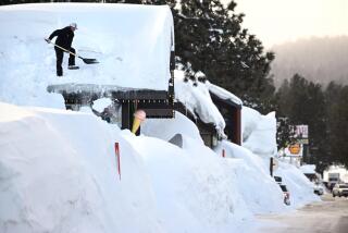 El propietario Brang Miller quita la nieve del tejado de Mammoth Fun Shop