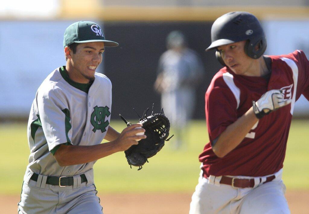 Costa Mesa High's Justin Fisher, left, chases down Estancia's Jason Rodriquez, right, for an out during the first inning on Wednesday.