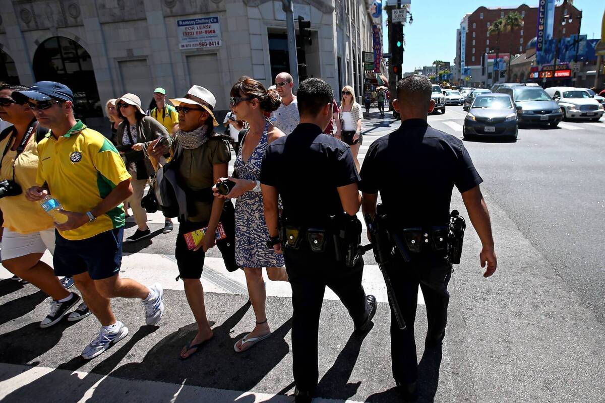 Police patrol at Hollywood Boulevard and Highland Avenue on Wednesday. A 'flash mob' of youths rampaged through the area Tuesday night, stealing from pedestrians and shops.