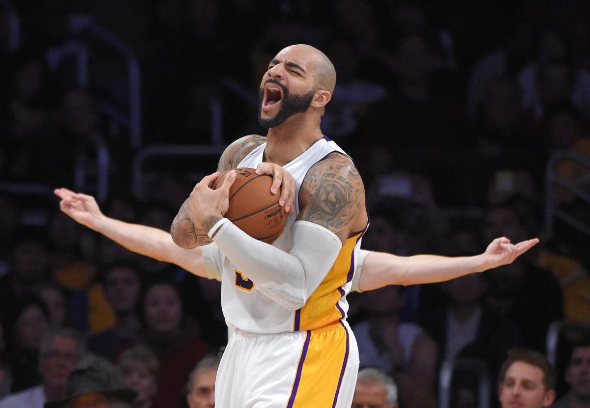 Lakers forward Carlos Boozer reacts after he's called for a foul by referee Eli Roe (background, arms extended) in the second half.