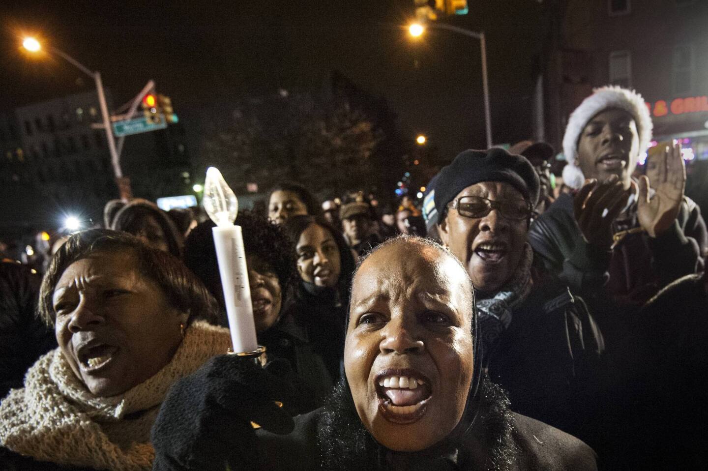 Mourners sing "This Little Light of Mine," during prayer vigil at site where two NYPD officers were fatally shot in Brooklyn borough of New York