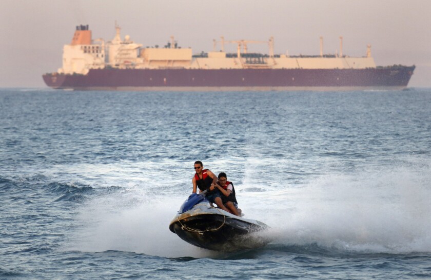 FILE - In this Friday, July 26, 2019 file photo, a ship crosses the Gulf of Suez towards the Red Sea as holiday-makers ride a jet ski at al Sokhna beach in Suez, 127 kilometers (79 miles) east of Cairo, Egypt. Not only are humans changing the surface and temperature of the planet, but also its sounds – and those shifts are detectable even in the open ocean, according to research published Thursday, Feb. 4, 2021. (AP Photo/Amr Nabil)