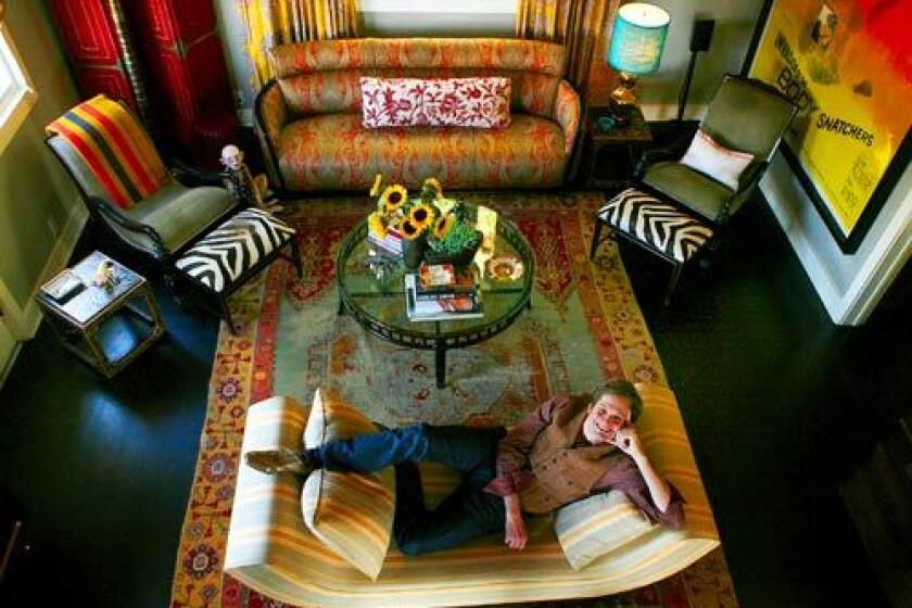 "Pushing Daisies" creator Bryan Fuller, shown here in his living room, reined in a love of horror-flick kitsch and sci-fi action figures while re-imagining his Silver Lake house. With the help of designer Betsy Burnham, most of the toys were cleared from the living room to make way for beautiful fabrics, interesting furniture and more grown-up accessories. "Bryan had his own style, a dark whimsy," says Burnham, who wanted to preserve Fuller's personality and sense of playfulness. Yes, that is a life-size Gollum sculpture in the upper-left corner. On the right wall: a vintage "Invasion of the Body Snatchers" poster. Both take their place with the sofa upholstered in a rich Schumacher paisley and the large Oushak rug.
