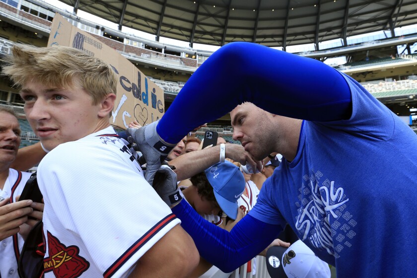The Dodgers are the first Freddie Freeman base to sign autographs to spectators in Atlanta before Friday's game.