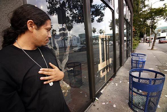 Richard Torres, owner of the Holy Grail shoe store, stands in front of his boarded-up shop. Torres' store was emptied of its stock by looters during the rioting that followed Sunday night's Lakers victory.