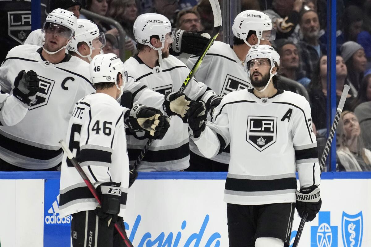 The Kings' Phillip Danault, right, is congratulated by players on the bench after scoring in the second period Jan. 28, 2023.