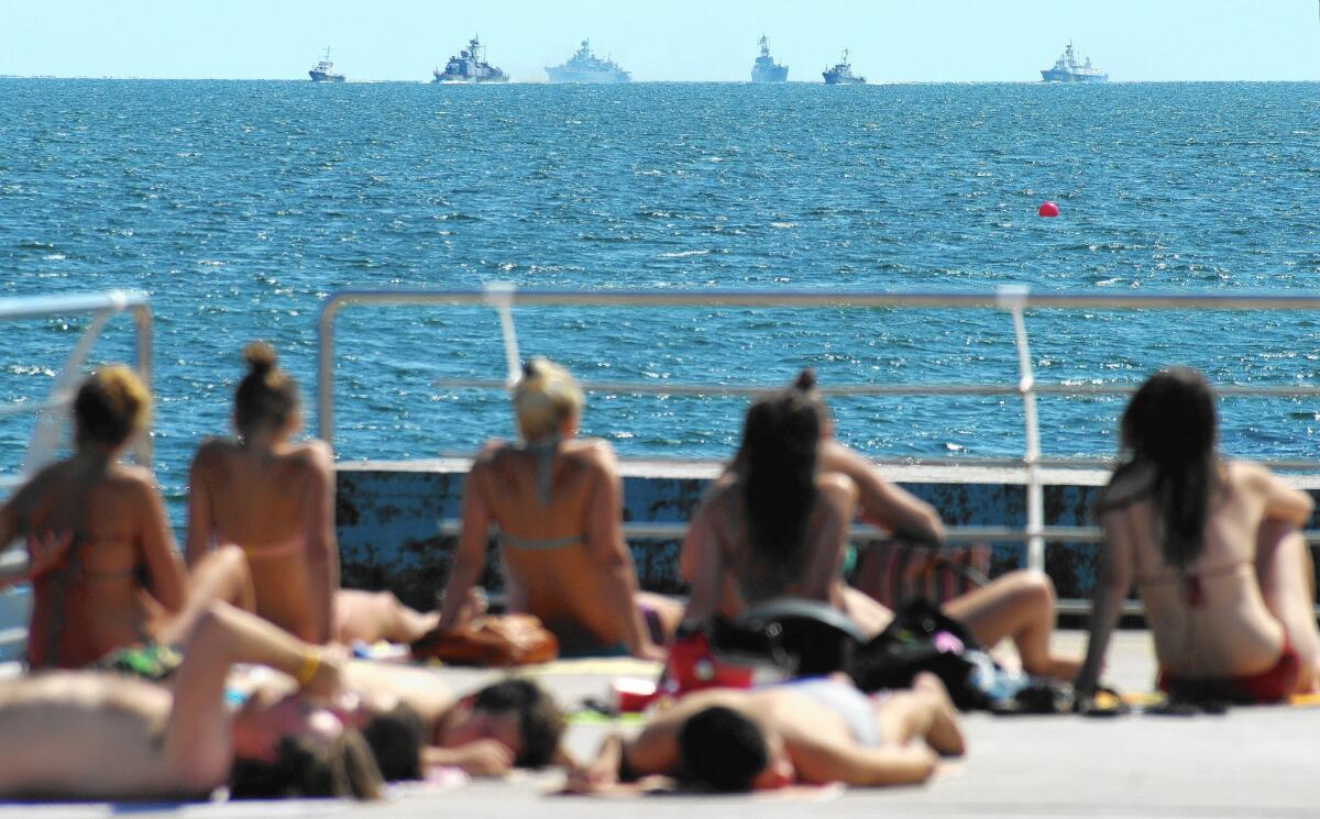 Sunbathers in the southern Ukrainian city of Odessa watch in August as Ukrainian navy ships take part in exercises.