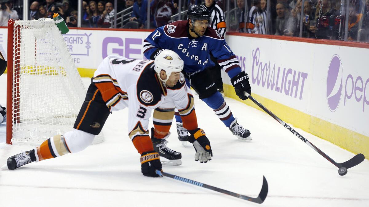 Ducks defenseman Clayton Stoner, front, tries to force Colorado forward Jerome Iginla into turning over the puck during the Ducks' 3-2 victory Sunday.